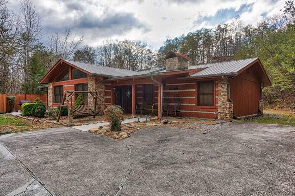 A rustic cabin with a stone foundation, wooden exterior, and a chimney. - Pigeon Forge*ZERO Stairs*Sleeps 10 (PIGEON FORGE)