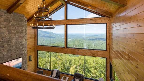 A room with large windows offering a view of a forested landscape, a wooden ceiling, and a chandelier. - Outdoor Games, Indoor Games, Incredible Views (SEVIERVILLE)