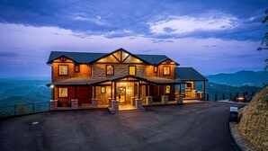 A large, multi-story stone and wood lodge with a covered porch and a view of the surrounding landscape. - Outdoor Games, Indoor Games, Incredible Views (SEVIERVILLE)
