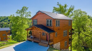 A multi-story wooden house with a porch, a covered front entrance, and a driveway. - Pigeon Forge*Resort*Dogs Welcome*Sleeps 12*Dollywood (SEVIERVILLE)
