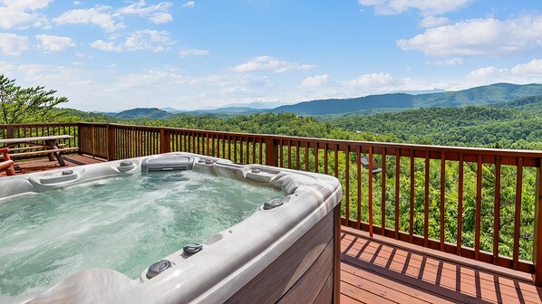 A hot tub on a wooden deck with a scenic mountain view. - Pigeon Forge*Luxury Plus*Slps 12*Incredible MTN View*Games (PIGEON FORGE)