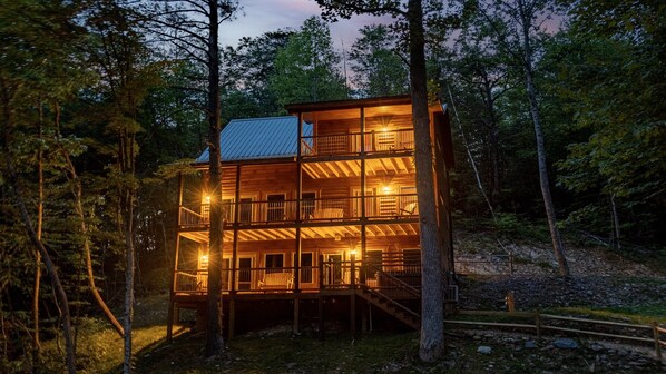 A multi-story wooden cabin with balconies, surrounded by trees. - Firepits, Putt Putt, And Private Pools (SEVIERVILLE)