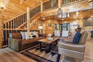 A wooden interior with a staircase, leather sofa, and a coffee table. - Basketball, Theater, & Private Swimming Pool (SEVIERVILLE)