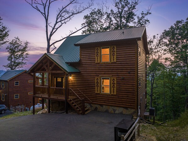 A log cabin with a porch, a staircase, and a view of the surrounding forest. - Private Pool*Awesome Views of the Strip*Game Room*Hot tub (GATLINBURG)