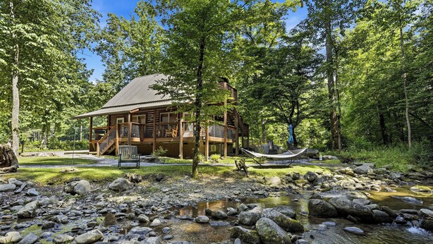 A wooden cabin with a deck, surrounded by a forest and a stream. - Near The Golf Corse, On The Creek (COSBY)