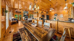 A spacious wooden cabin with a large dining table, kitchen area, and a cozy seating area. - Outdoor Fireplace And Gorgeous Mountain Views (SEVIERVILLE)