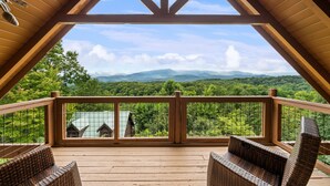 A wooden deck with wicker furniture overlooking a mountainous landscape. - Outdoor Fireplace And Gorgeous Mountain Views (SEVIERVILLE)