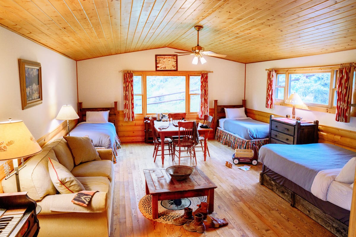 A cozy cabin with two bedrooms, a dining area, and a piano.