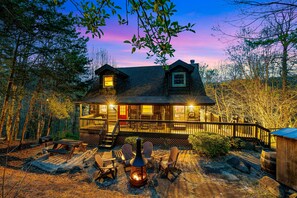 A cabin with a deck, outdoor seating, and a wood-burning stove. - Screened In Hot Tubs Bring Joy All Year Round (GATLINBURG)