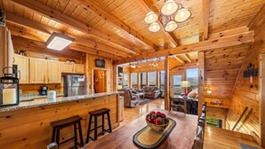 A wooden cabin interior with a kitchen, dining area, and living room. - 1 Awesome View - Secluded Cabin In Pigeon Forge (PIGEON FORGE)
