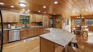 A wooden cabin interior with a kitchen, dining area, and a large window. - 3 Crazy Cubs-Close to Pigeon Forge and Dollywood (SEVIERVILLE)