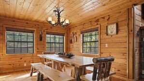 A wooden cabin interior with a large dining table, benches, and a chandelier. - 3 Crazy Cubs-Close to Pigeon Forge and Dollywood (SEVIERVILLE)