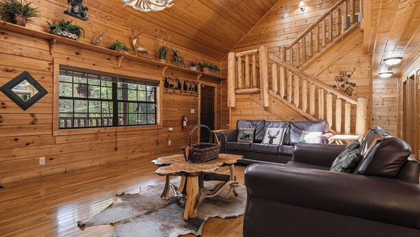 A wooden interior with a staircase, a sofa, a table, and decorative items. - 3 Crazy Cubs-Close to Pigeon Forge and Dollywood (SEVIERVILLE)