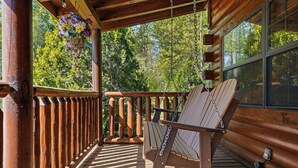 A wooden deck with a swing chair and a hanging flower basket. - 3 Crazy Cubs-Close to Pigeon Forge and Dollywood (SEVIERVILLE)