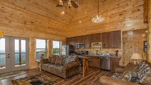 A wooden cabin interior with a kitchen, dining area, and seating with a view. - 4 States View-Gatlinburg, Private Pool, Game Room (GATLINBURG)