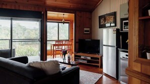 A cozy living room with a sofa, TV, and wooden cabinets.