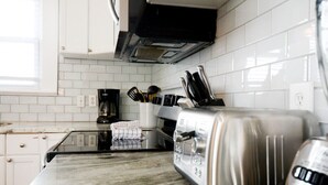 Een keuken met witte kasten, een roestvrijstalen toaster en een koffiezetapparaat.