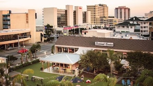 Een hotel met een Festival Center bord, zitplaatsen buiten en palmbomen.