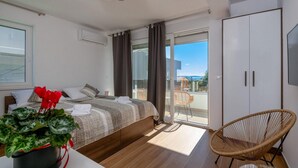 A modern bedroom with a bed, a chair, and a view of the outdoors. - 2 bedroom nice home in Vodnjan (Vodnjan)