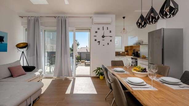 A modern kitchen with a wooden countertop, a stainless steel refrigerator, and a dining area with a wooden table set for two. - 2 bedroom nice home in Vodnjan (Vodnjan)