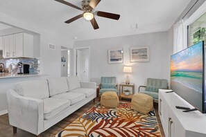 A living room with a sofa, two armchairs, a coffee table, a TV, and a ceiling fan. - Fenced in w/ Jacuzzi Close to Siesta Key Bridge (Sarasota)