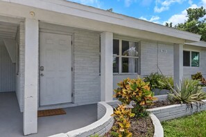 A single-story building with a white exterior, a front door, and a small porch area. - Fenced in w/ Jacuzzi Close to Siesta Key Bridge (Sarasota)