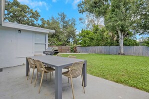 A patio with a table and chairs, a grill, and a fenced yard. - Fenced in w/ Jacuzzi Close to Siesta Key Bridge (Sarasota)