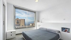 A bedroom with a large window, a bed, a nightstand, and a wall-mounted picture. - Holiday Villa 'Tulio Homme 2' with Sea Views, Private Pool and Wi-Fi (Adeje)