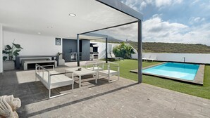 A modern outdoor living area with a pool, seating, and a view of the landscape. - Holiday Villa 'Tulio Homme 2' with Sea Views, Private Pool and Wi-Fi (Adeje)