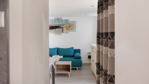 Ein modernes Wohnzimmer mit einem blauen Sofa, einem Holztisch und einem Gemälde an der Wand.