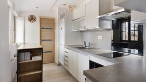 Eine moderne Küche mit Backofen, Edelstahl-Spüle und Holztür.