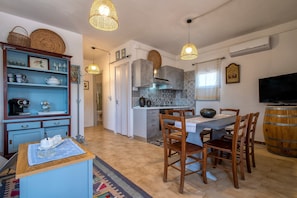 Una cocina con una mesa de comedor, sillas y un televisor.