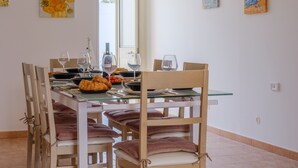 A dining area with a glass table, wooden chairs, and a window. - Villa 'Maestrale Torre Lapillo' with Private Terrace, Wi-Fi and Air Conditioning (Porto Cesareo)