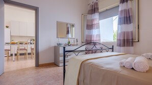 A bedroom with a bed, a desk, a chair, a mirror, and a window with curtains. - Villa 'Maestrale Torre Lapillo' with Private Terrace, Wi-Fi and Air Conditioning (Porto Cesareo)