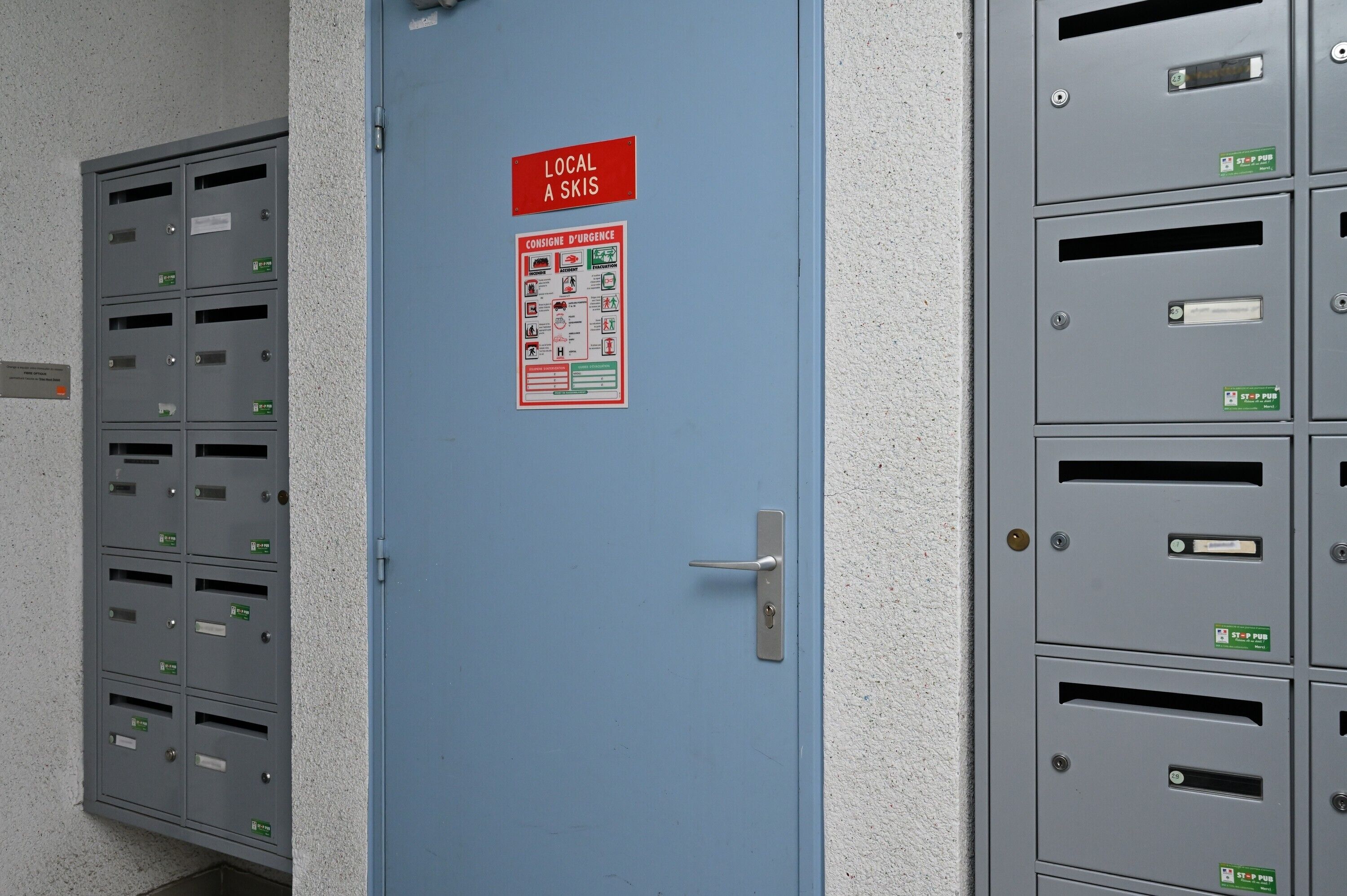 A blue door with a red sign reading 'LOCAL A SKIS' and a safety poster.