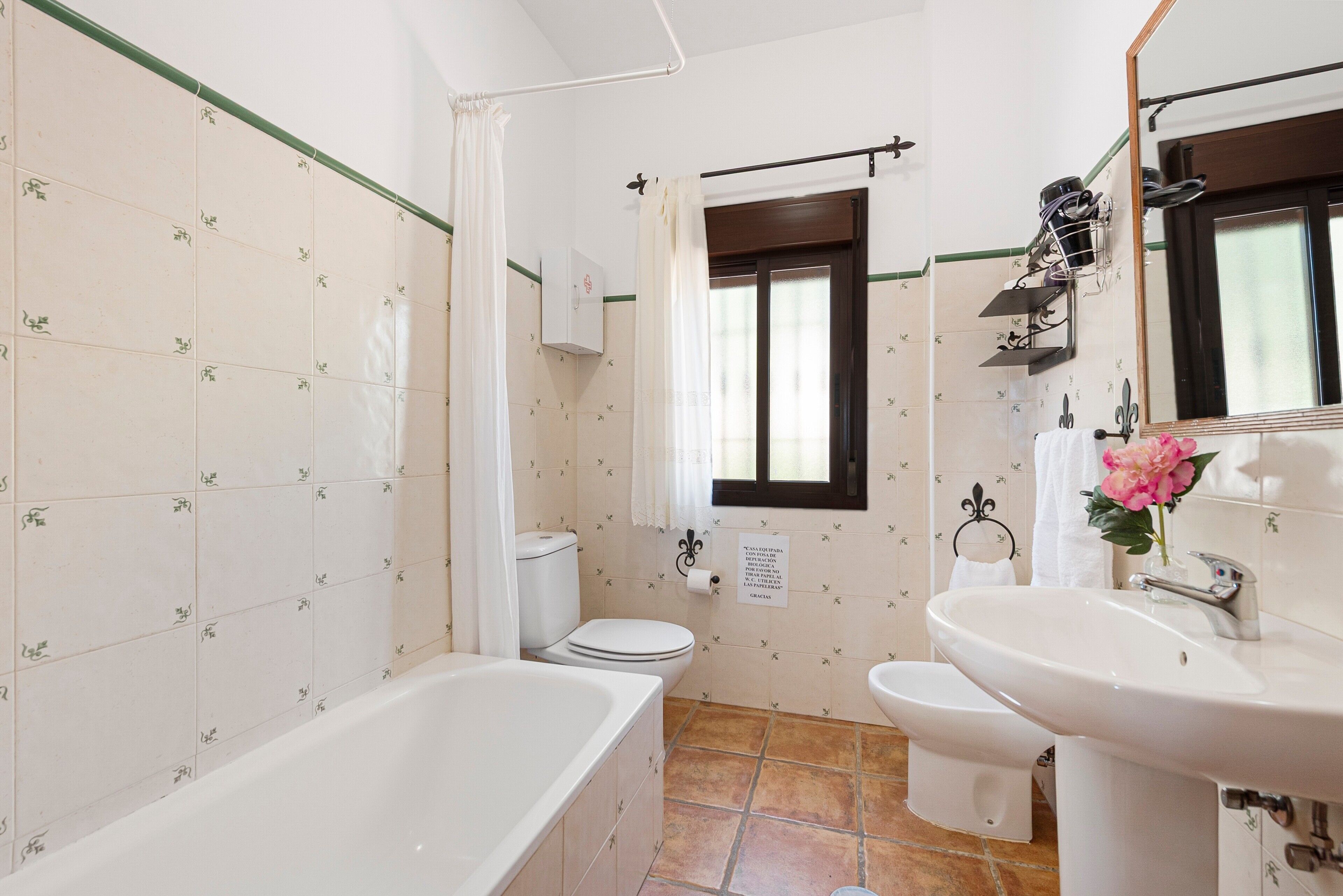 A bathroom with a bathtub, toilet, bidet, and sink.