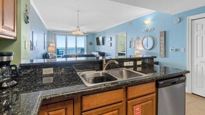 A kitchen with granite countertops, stainless steel appliances, and wooden cabinets. - Breathtaking 16th-Floor Gulf Views • Sleeps 8 • Ariel Dunes II (Destin)