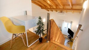 Un intérieur moderne avec un plafond en bois, une table en verre, une chaise jaune et un petit arbre.