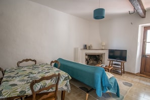 Une pièce comprenant un lit, une table, un téléviseur et une cheminée.