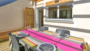Mesa dispuesta para cuatro personas, con copas de vino, platos y cubiertos.