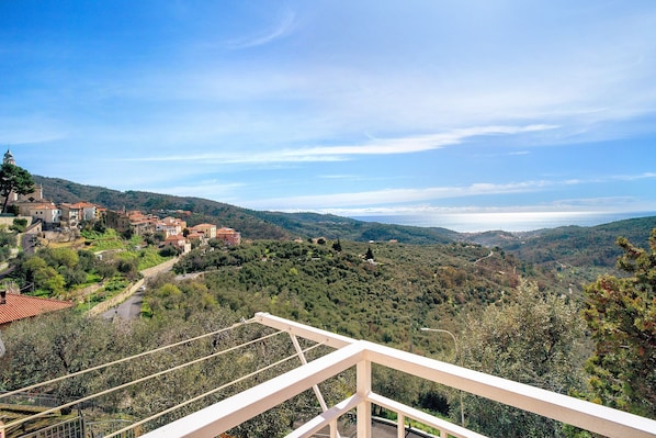 Un village perché sur une colline, avec des bùtiments traditionnels, un ciel dégagé et une vue imprenable sur les environs.