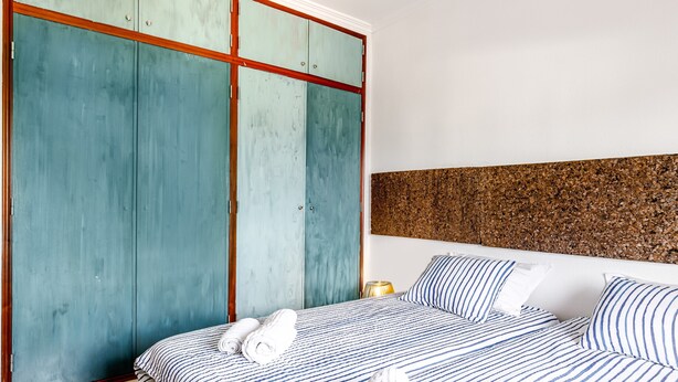 A bedroom with a bed, a wardrobe, and a headboard. - Villa 'Sublime Sun and Van, By Meco Stays' with Balcony and Wi-Fi (Alfarim)