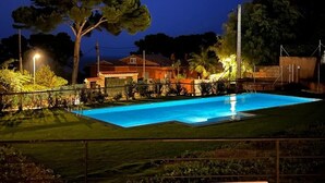 A swimming pool at night with surrounding greenery and a house. - Apartment 'Bonavista Begur' with Sea View, Wi-Fi and Air Conditioning (BEGUR)