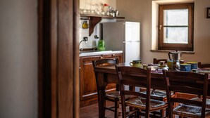 A kitchen with wooden cabinets, a refrigerator, and a window.
