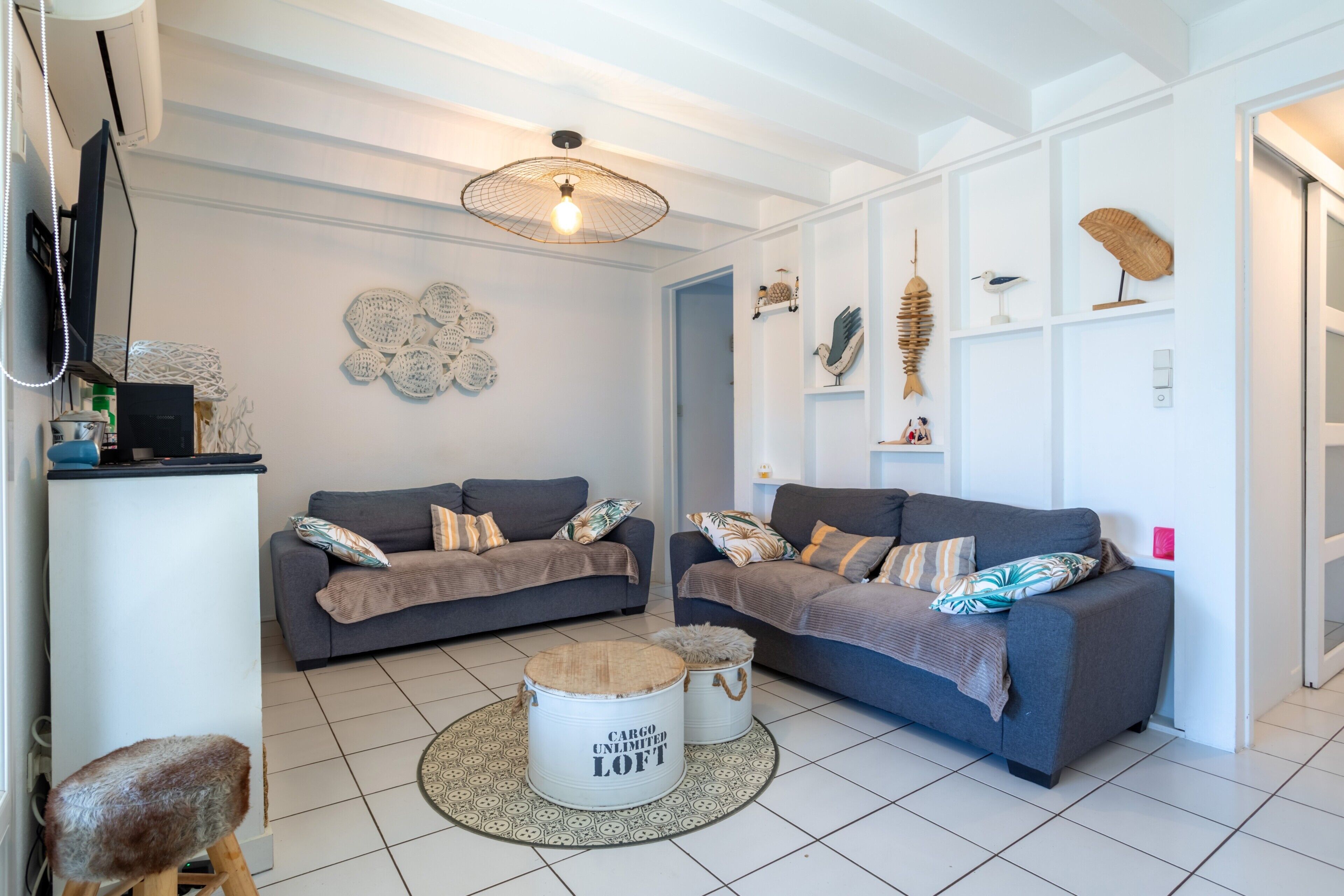 A living room with two grey sofas, a round coffee table, and decorative items on the walls.