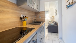 Une cuisine moderne avec des meubles en bois, une cuisinière encastrée et un évier.
