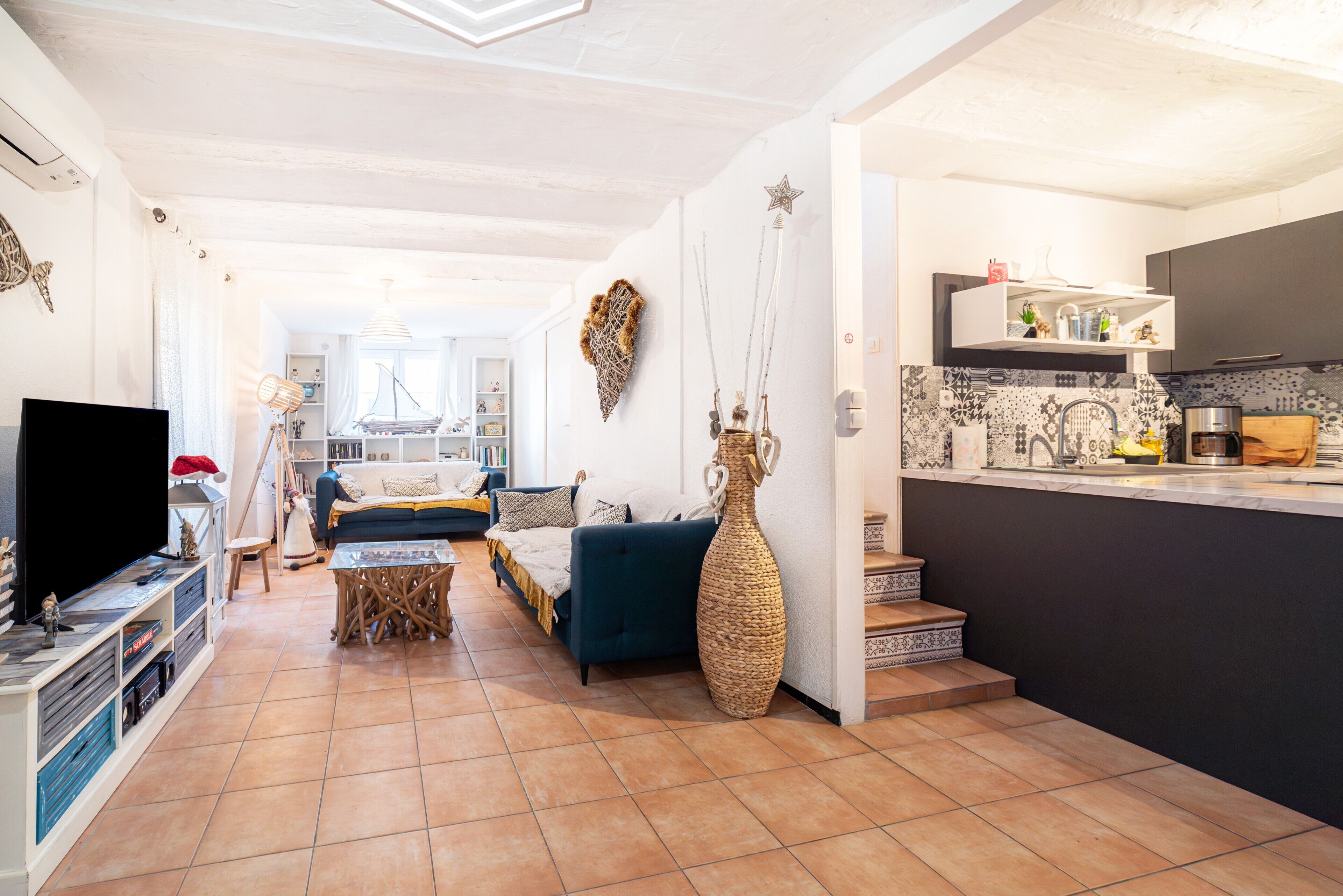 Una sala de estar con sofá, televisor y objetos decorativos.