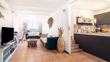 Una sala de estar con sofá, televisor y objetos decorativos.