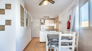 A compact kitchen with white cabinets, a microwave, and a window with a view. - Apartment 'Córdula' with Wi-Fi and Air Conditioning (Es Pujols)