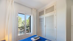 A bedroom with a bed, a window, and a balcony. - Apartment 'Isla Blanca' with Air Conditioning (Es Pujols)